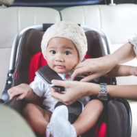 A baby getting into car sear A baby getting into car sear
