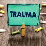 Green sign that reads trauma - to highlight that traumatic injury can result in conditions such as Complex Regional Pain Syndrome (CPRS)